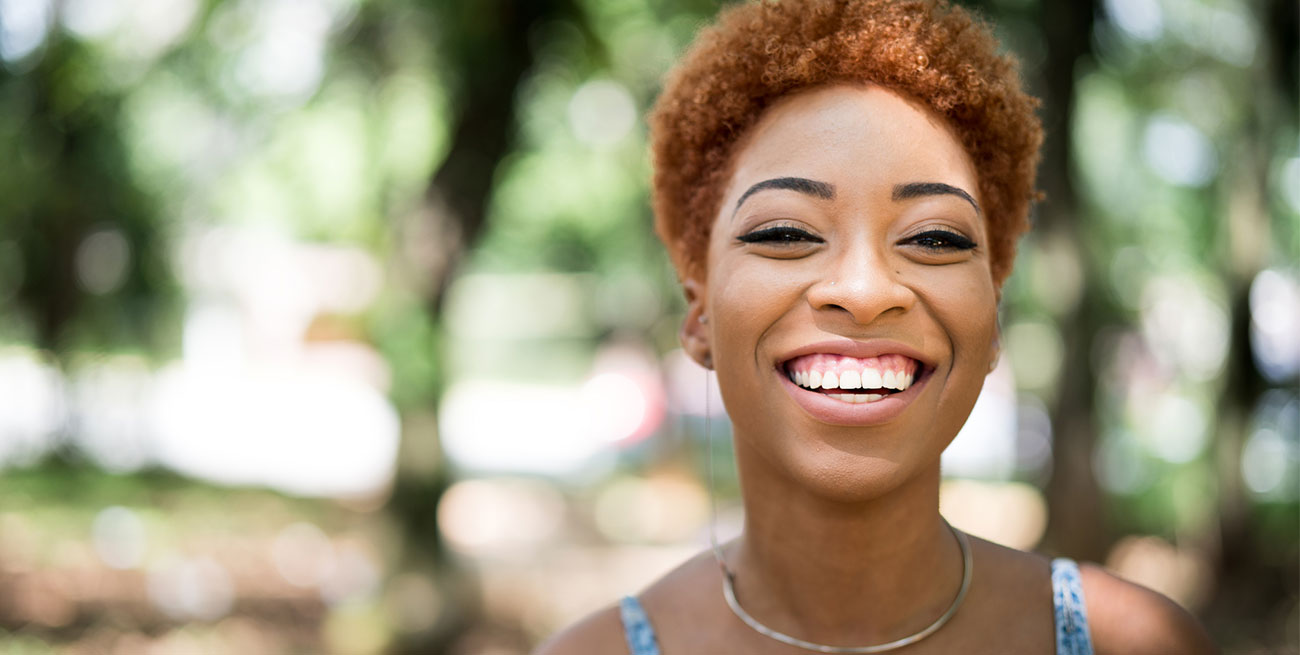 Mulher jovem negra sorrindo no parque